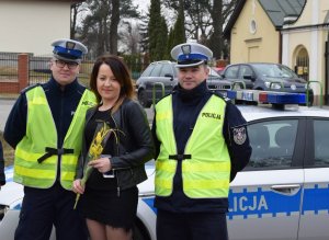 policjant wręcza kwiaty kobiecie będącej uczestniczka ruchu