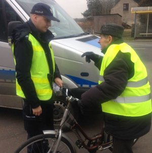 rowerzyści otrzymują kamizelki od patrolu Policji