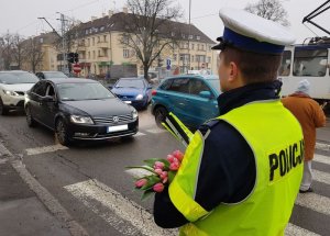 policjanci wręczają tulipany kobietom korzystającym z drogi z godnie z przepisami prawa
