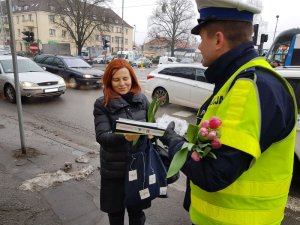 policjanci wręczają tulipany kobietom korzystającym z drogi z godnie z przepisami prawa
