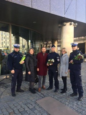 policjanci i dziennikarze z kwiatami