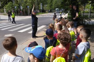Dzieci uczą się przechodzenia przez przejście dla pieszych po okiem policjantów w towarzystwie koszykarza Trefla Sopot