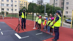 dzieci wraz z policjantami podnoszą swoje umiejętności w miasteczku ruchu drogowego