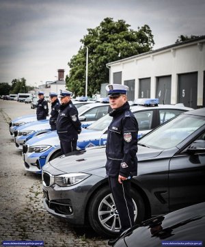 policjanci ruchu drogowego stoją przy nowych pojazdach oznakowanych i nieoznakowanych marki BMW