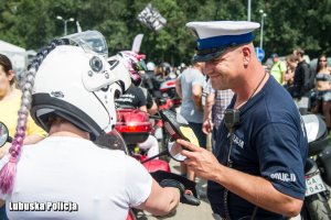 policjant ruchu drogowego bada stan trzeźwości jednego z uczestników zlotu motocyklowego