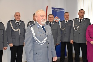 policjant z 50-letnim stażem pracy w mundurze na tle kolegów
