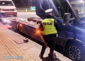 policjant ruchu drogowego stojący obok samochodu z lawetą