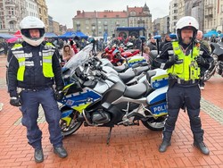 dwóch policjantów - motocyklistów na rynku, w tle motocykle