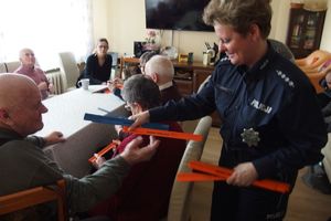 policjanci rozdają seniorom elementy odblaskowe