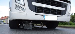 samochód ciężarowy pod którym znajduje się rower