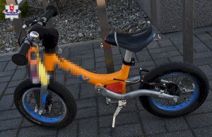 na zdjęciu widnieje żółty dziecięcy rowerek