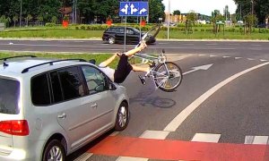 Obrazek przedstawia pojazd na przejściu dla pieszych i przejeździe dla rowerów. Przed pojazdem znajduje się rowerzysta, który został przez niego potrącony - rowerzysta i rower są nad pojazdem.