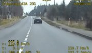 zdjęcie jest stop-klatka z policyjnego wideorejestratora, widać na nim samochód w kolorze ciemnoszarym jadący na pustej drodze dwukierunkowej