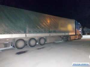 Zdjęcie przedstawia ciężarówkę (Tita), który stoi na ośnieżonej drodze. Kabina ciężarówki jest w kolorze granatowym. Zdjęcie zostało zrobione w nocy i pokazuje ciężarówkę z boku.