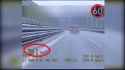 zdjęcie jest stop klatka z wideorejestratora przedstawia samochód szarym kolorze, który porusza się droga ekspresową