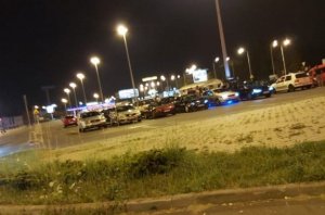 Zdjęcie zrobione w nocy, widać na nim dożą liczbę samochodów osobowych stojących na parkingu
