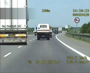 stop-klatka z wideorejestratora, widać jak samochód ciężarowy rozpoczyna manewr wyprzedzania innego pojazdu mimo, ze przy drodze toi znak zakaz wyprzedzania