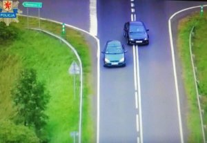 Zdjęcie z policyjnego droga, na którym samochód osobowy wyprzedza inny samochód w miejscu gdzie jest podwójna linia ciągła.