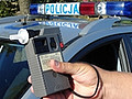 policjant trzyma w ręku urządzenie do badania alkoholu w wydychanym powietrzu
