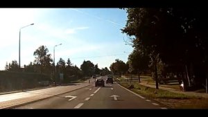 Stop klatka z filmu, widać jak samochód osobowy wyprzedza inny samochód w niedozwolonym miejscu.