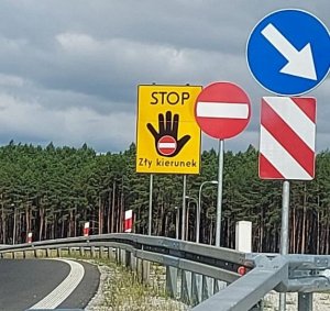 zdjęcie drogi przy której umieszczony jest znak drogowy z napisem STOP - zły kierunek