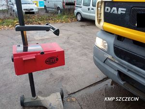 policjant ruchu drogowego sprawdza ustawienie świateł w ciężarowce przy pomocy specjalistycznego urządzenia