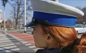 Zdjęcie  policjantki stojącej w pobliżu przejścia dla pieszych