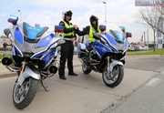 zaparkowane motocykle policyjne, obok dwóch policjantów w mundurach i kaskach motocyklowych