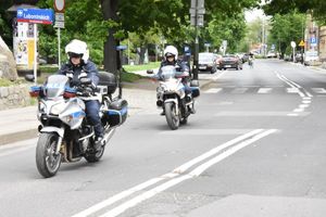 Na drodze znajdują się dwaj policjanci na motocyklach policyjnych.