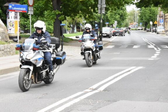 Na drodze znajdują się dwaj policjanci na motocyklach policyjnych.