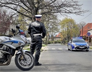 policjant w umundurowaniu stoi obok motocykla