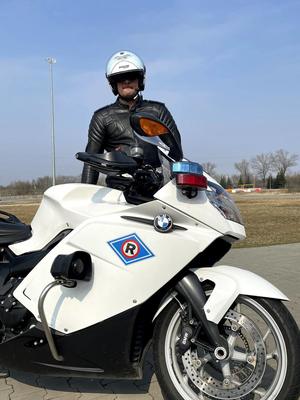 policjant stoi przy oznakowanym motocyklu marki BMW