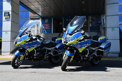 dwa oznakowane motocykle policyjne stoją przed budynkiem