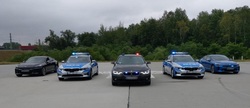pięć stojących policyjnych radiowozów oznakowanych i nieoznakowanych