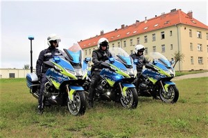 trzy policyjne motocykle na tle budynku