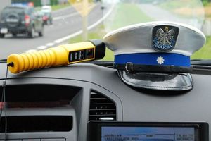 policyjna czapka i urządzenie do badania alkoholu w wydychanym powietrzy leżą w radiowozie