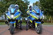 dwóch motocyklistów na oznakowanych motocyklach policyjnych pozuje do zdjęcia