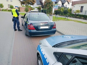 policjant stoi obok taksówki w kolorze zielonym