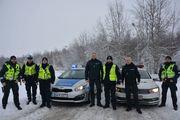 polscy i litewscy policjanci stoją na tle radiowozu