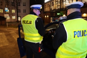 dwóch policjantów stoi obok samochodu osobowego