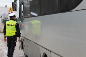 policjant stoi obok autobusu
