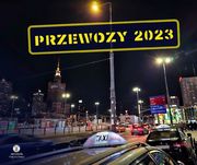 miejska ulica wieczorem, napis żółtą czcionka Przewozu 2023