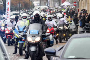 policyjni motocykliści jadą w gronie innych motocyklistów
