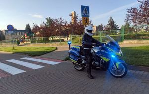 policjant obok oznakowanego motocykla