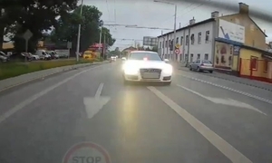 biały samochód jadący droga z włączonymi światłami