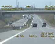 zdjęcie z wideorejestratora, na którym widać ciemną sylwetkę jadącego samochodu z tylu