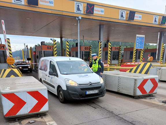 bramka na autostradzie, policjant kontroluje trzeźwość kierowcy w białym samochodzie