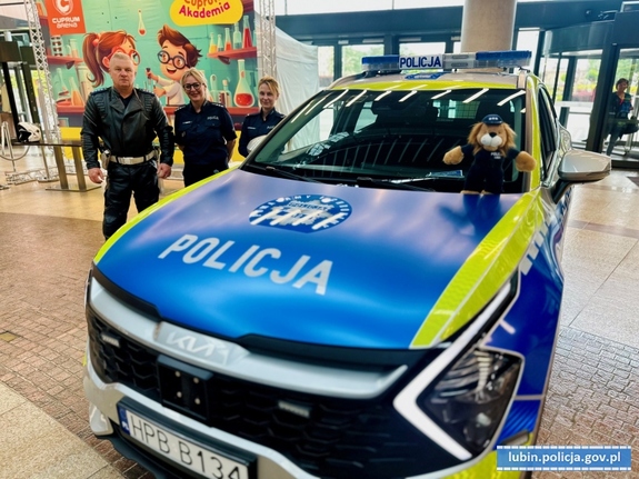 radiowóz policyjny obok stoją policjanci