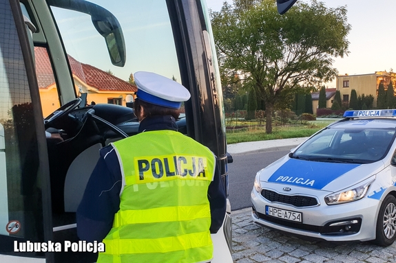 policjant stoi przy autokarze