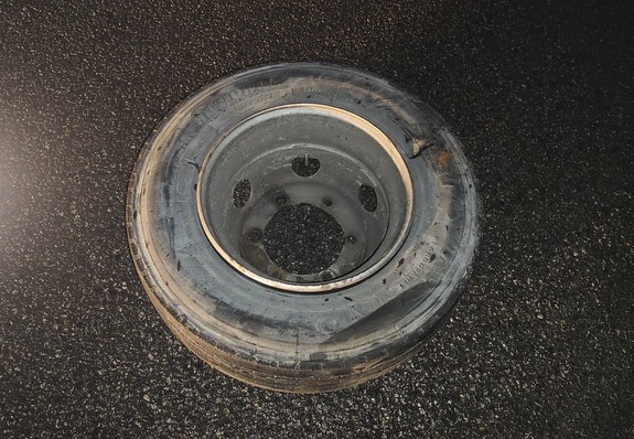 urwane koło lezy na asfalcie